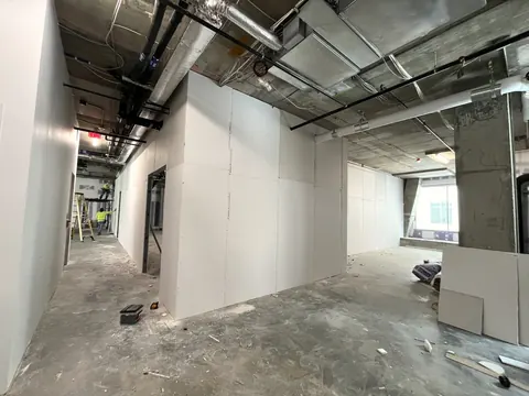 Fresh drywall partitions along a corridor.