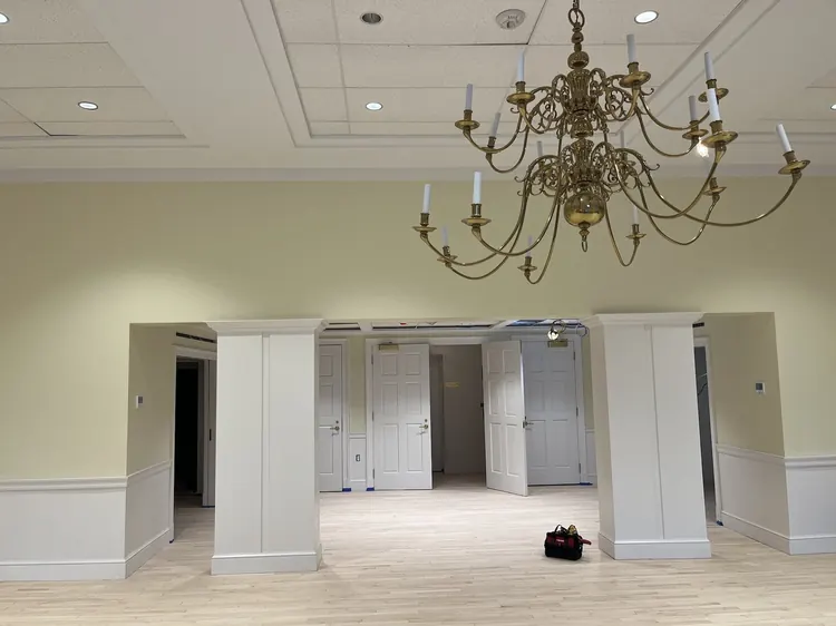 The Dumbarton House ballroom after renovation, brass chandelier under the new ceiling.