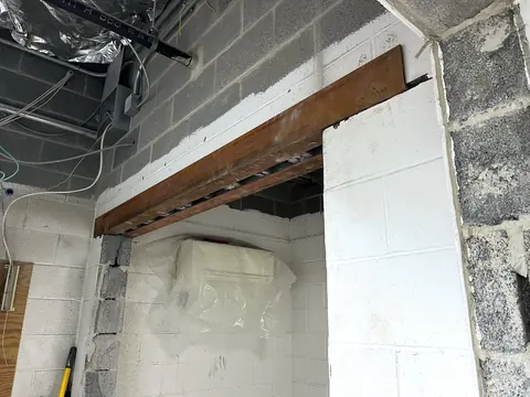 A new opening in a block wall carried by a steel lintel.