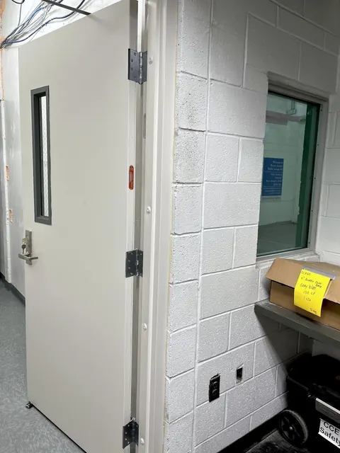 A finished hollow-metal door with a vision panel.