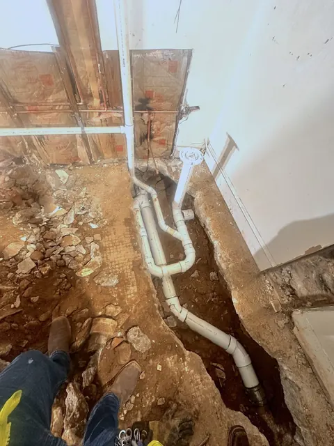 A trench cut in the slab with new drain piping laid in.